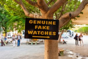 A sign pointing to 'genuine fake' goods